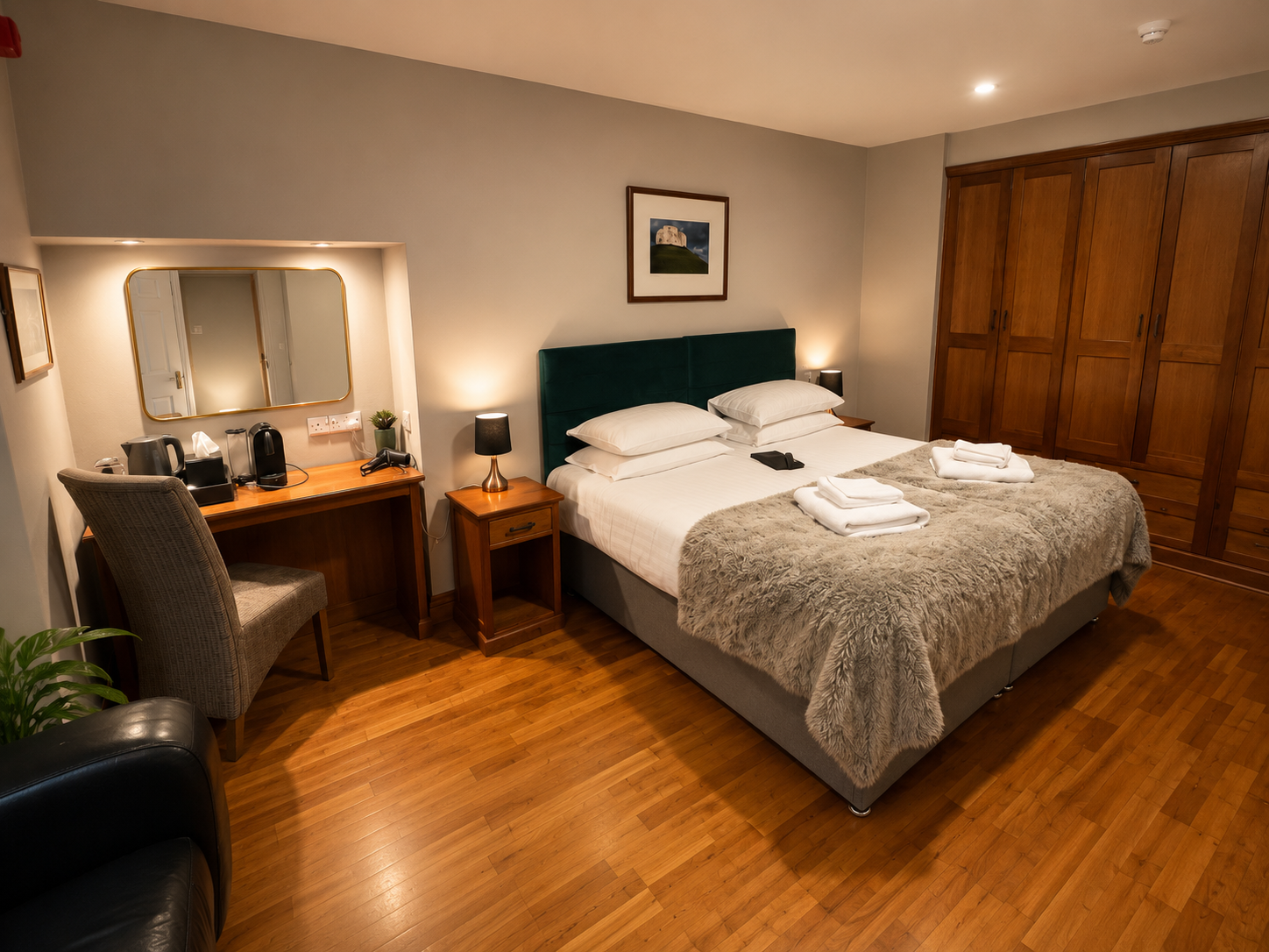 Bedroom with a bed, TV, radiator, bathroom door, and a window with seating area.