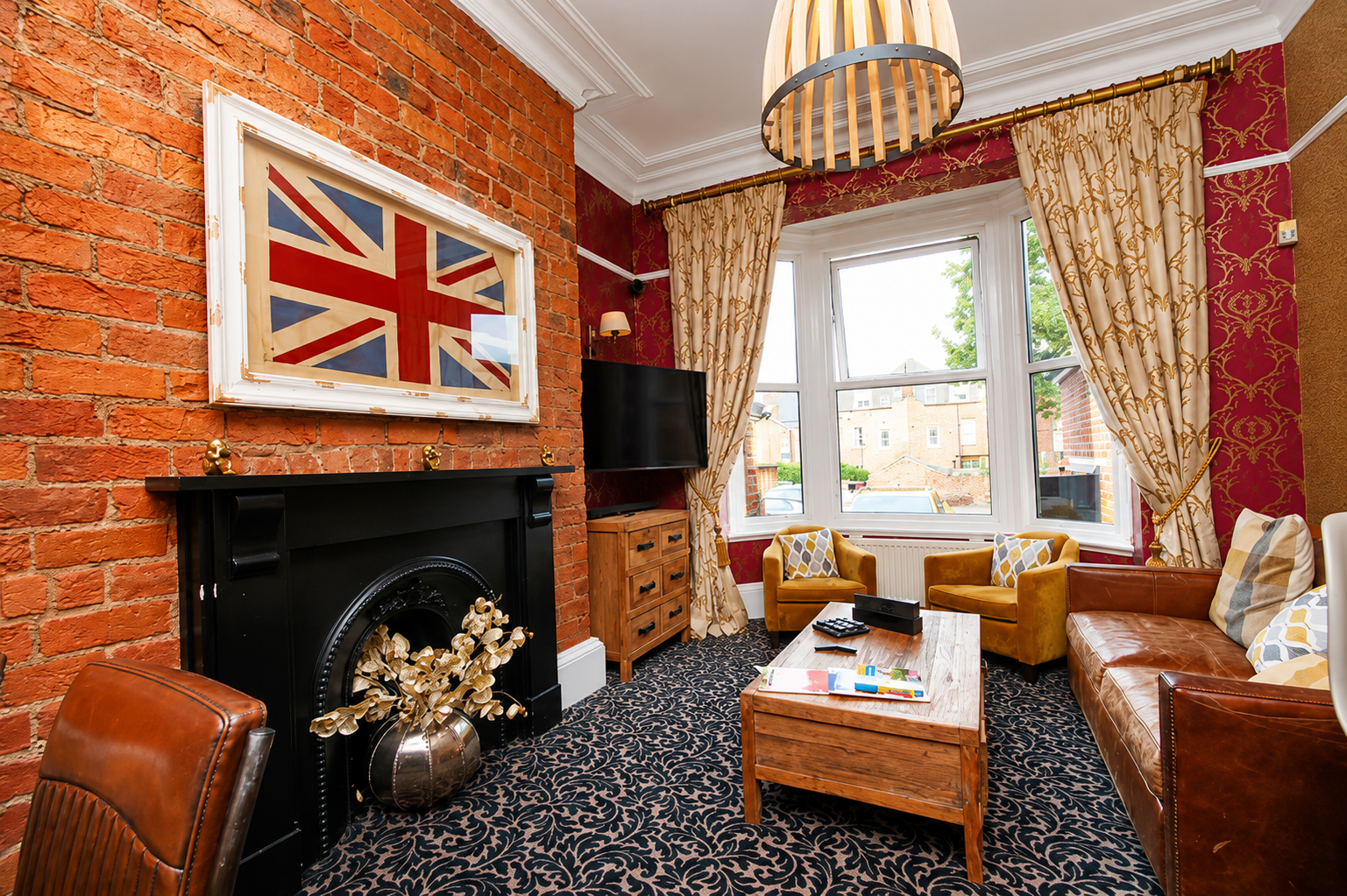 Living room with exposed brick, Union Jack art, sofa, armchairs, and coffee table.