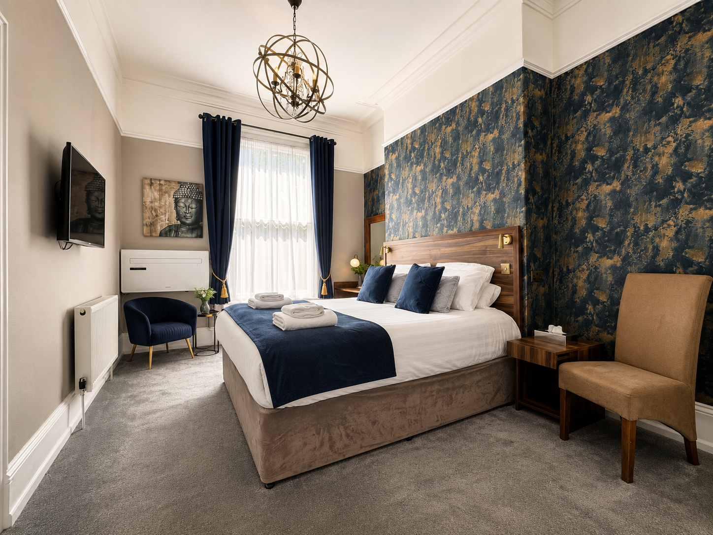 Hotel room with two beds, neutral walls, wooden floors, and a warm, inviting ambiance.