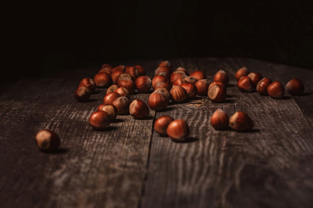 Castagne sparse su un tavolo di legno scuro in penombra