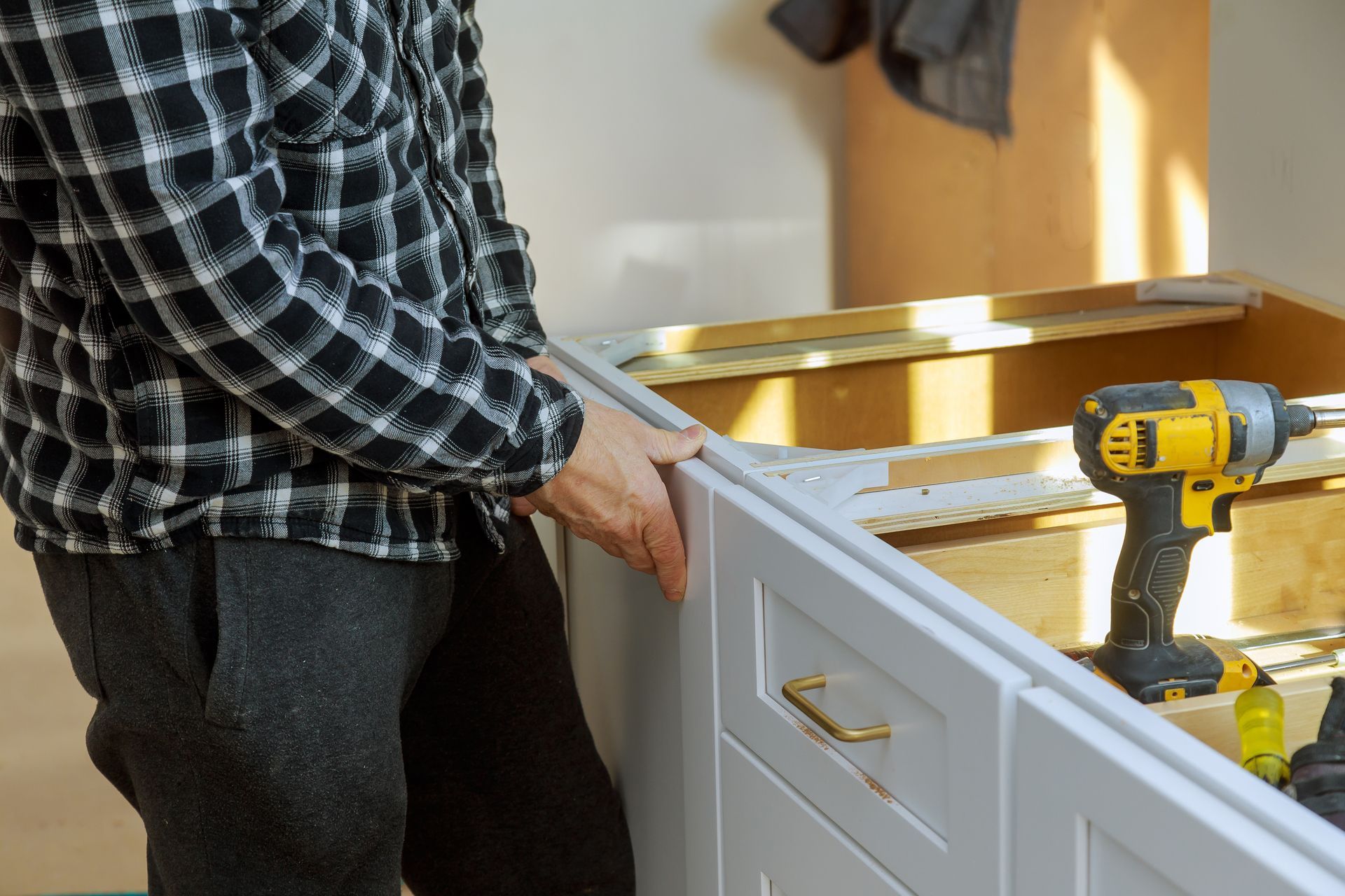 Assembling furniture white large trash can screws using a screwdriver