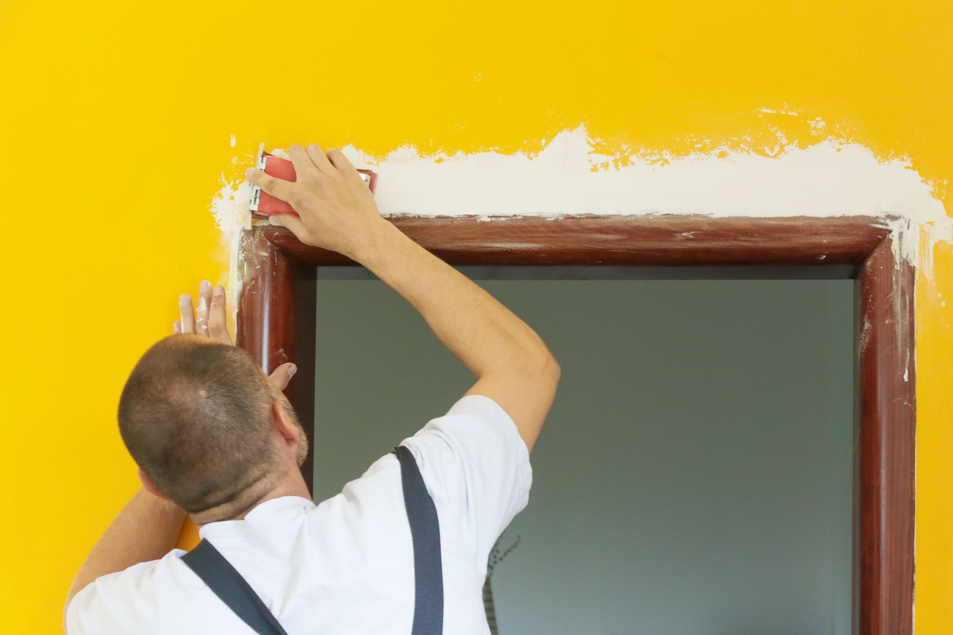 Sanding wall with a sanding block after skim coating