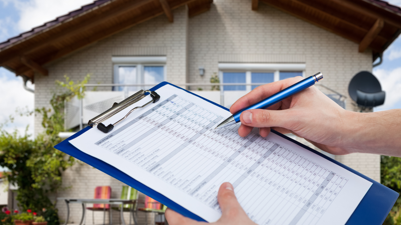 A person holding a clipboard with a chart in front of a house, suggesting a home inspection or assessment.