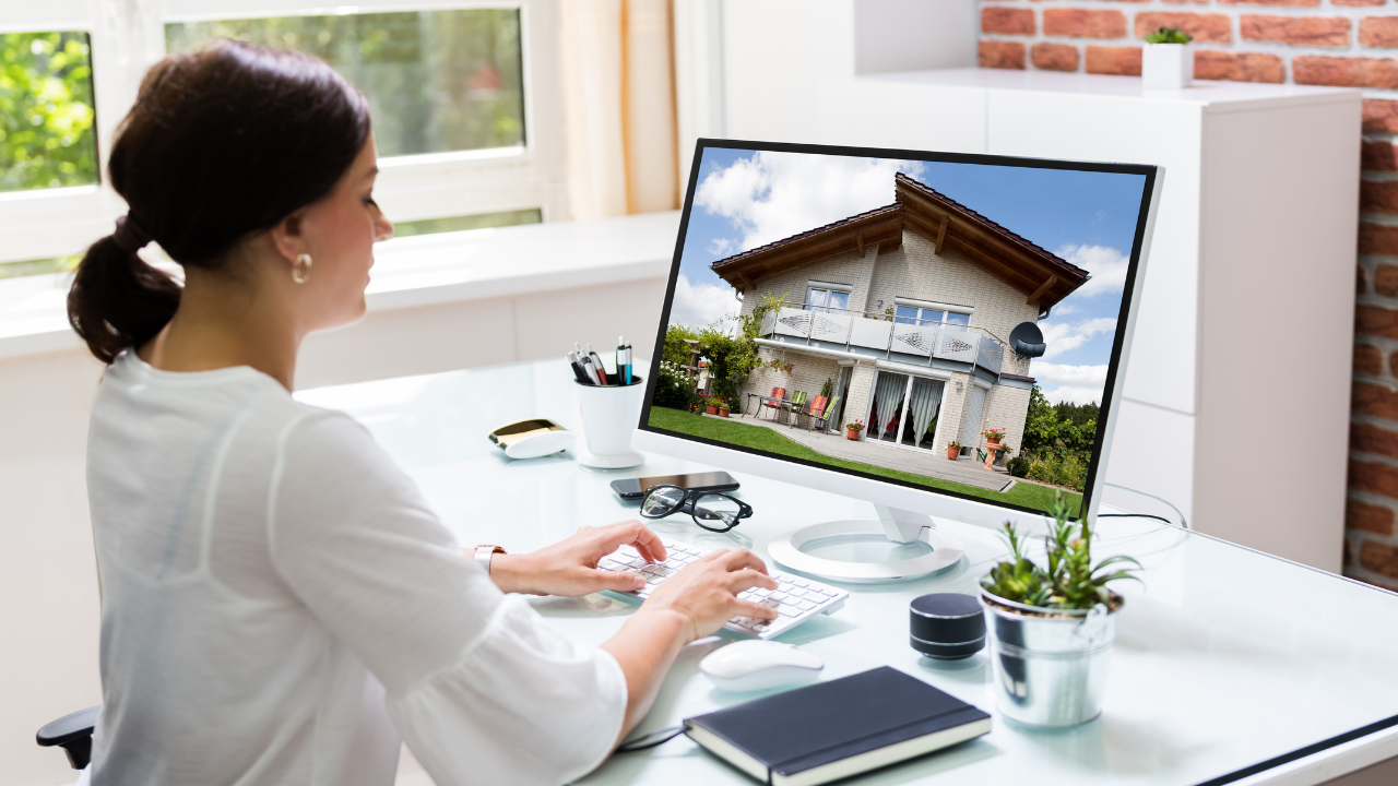 Woman viewing house listing on a computer in an office.