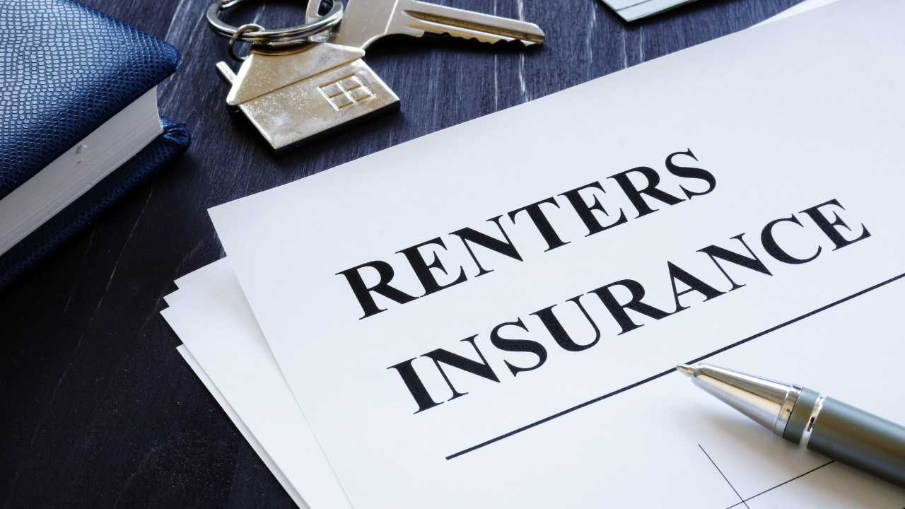 Renters insurance document with keys and pen on a dark surface.