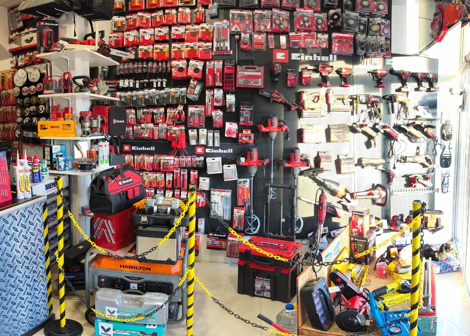 Dentro de una tienda de herramientas, las herramientas y los accesorios se exhiben en estantes y paredes.
