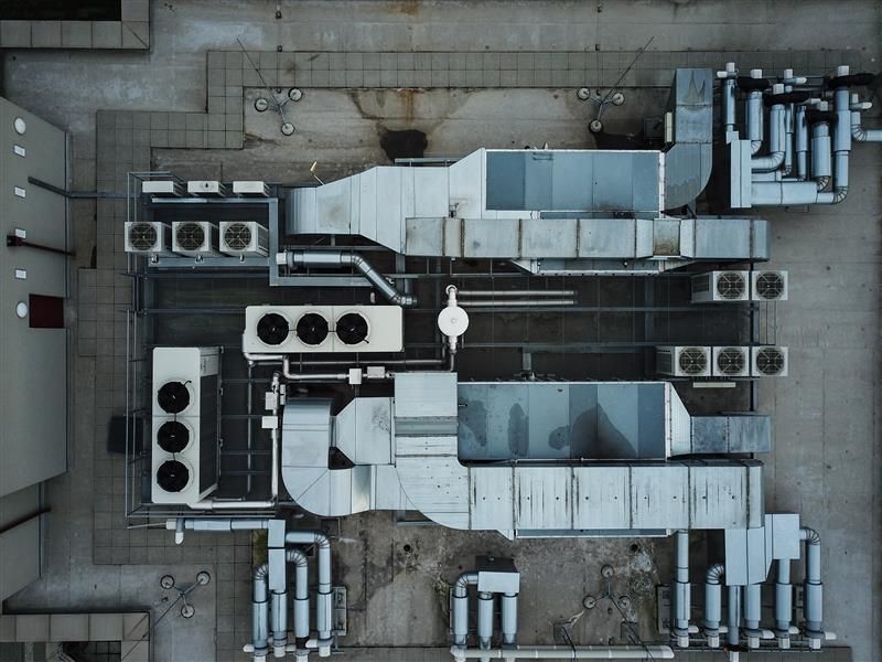Overhead view of HVAC equipment on a rooftop, including ductwork, air conditioning units, and ventilation.