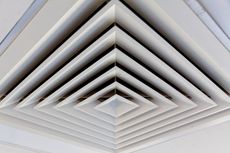 White square air vent in a ceiling, with a geometric, layered design.