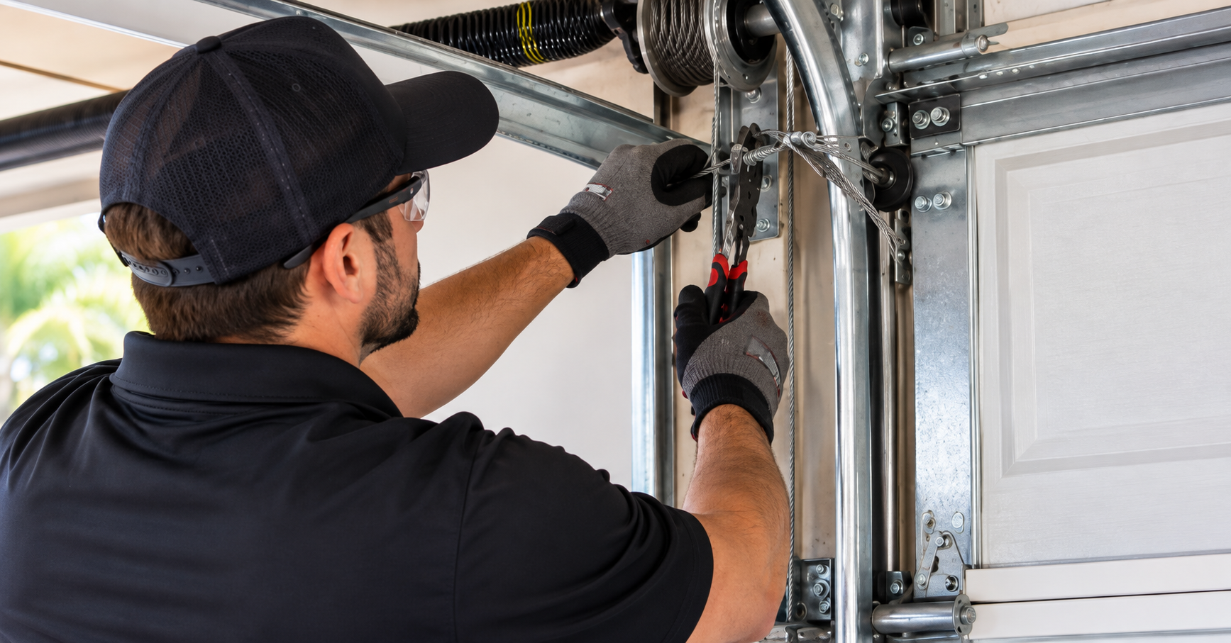 Garage door technician repairing a broken cable on a residential garage door