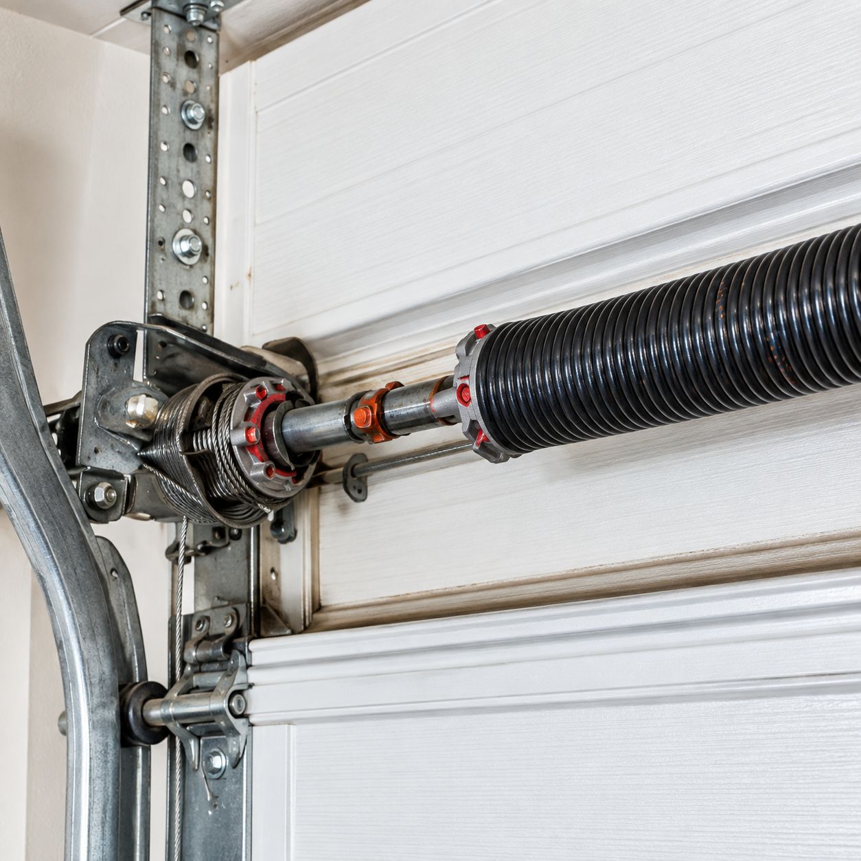 Professional inspecting garage door springs and cables