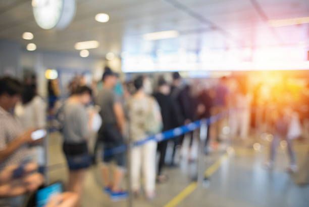A blurry picture of a crowd of people standing in line at an airport.