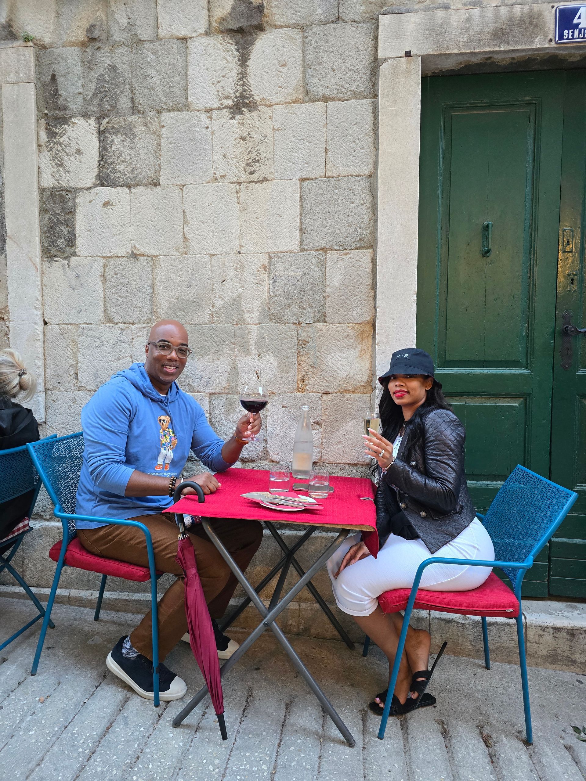 A man and a woman are sitting at a table drinking wine.