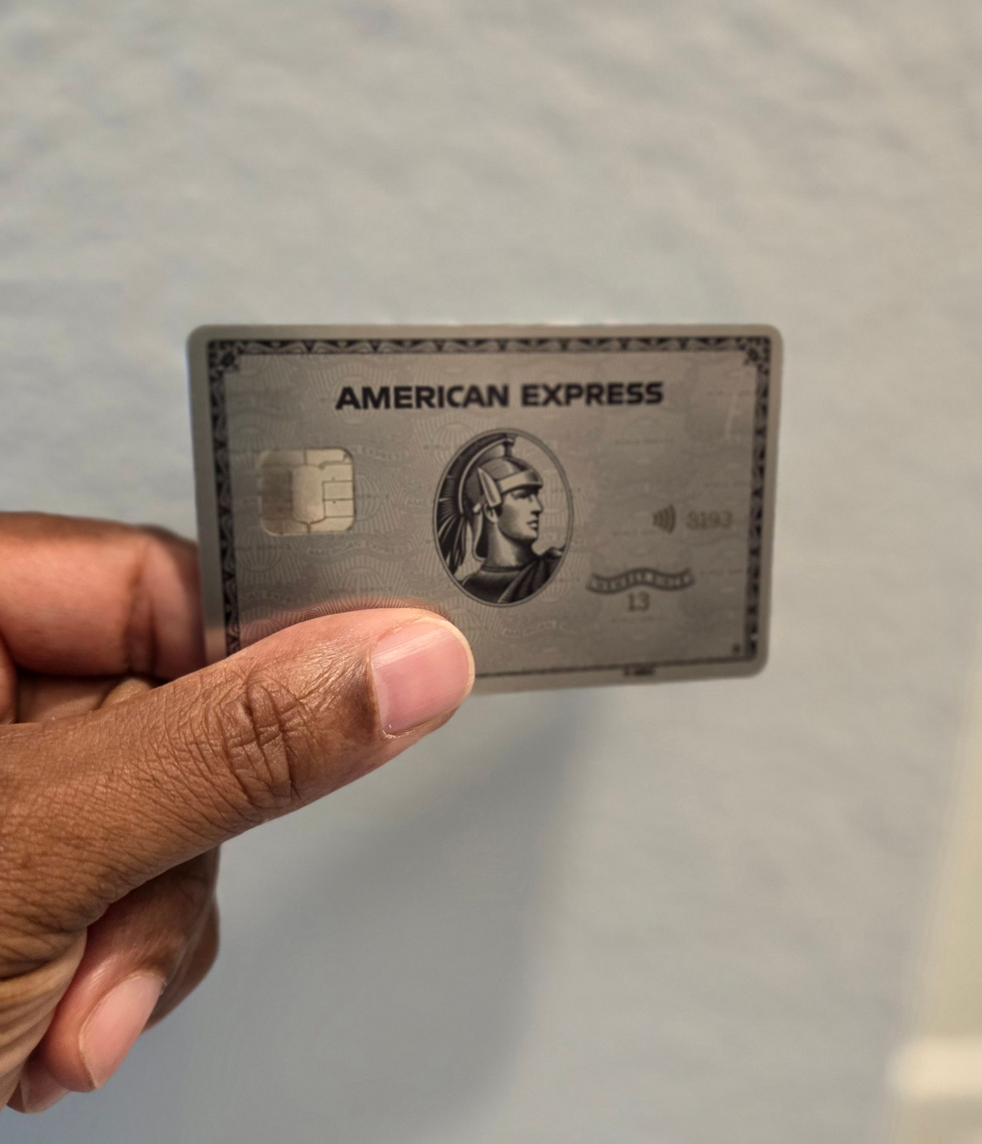 A person is holding an american express card in their hand.