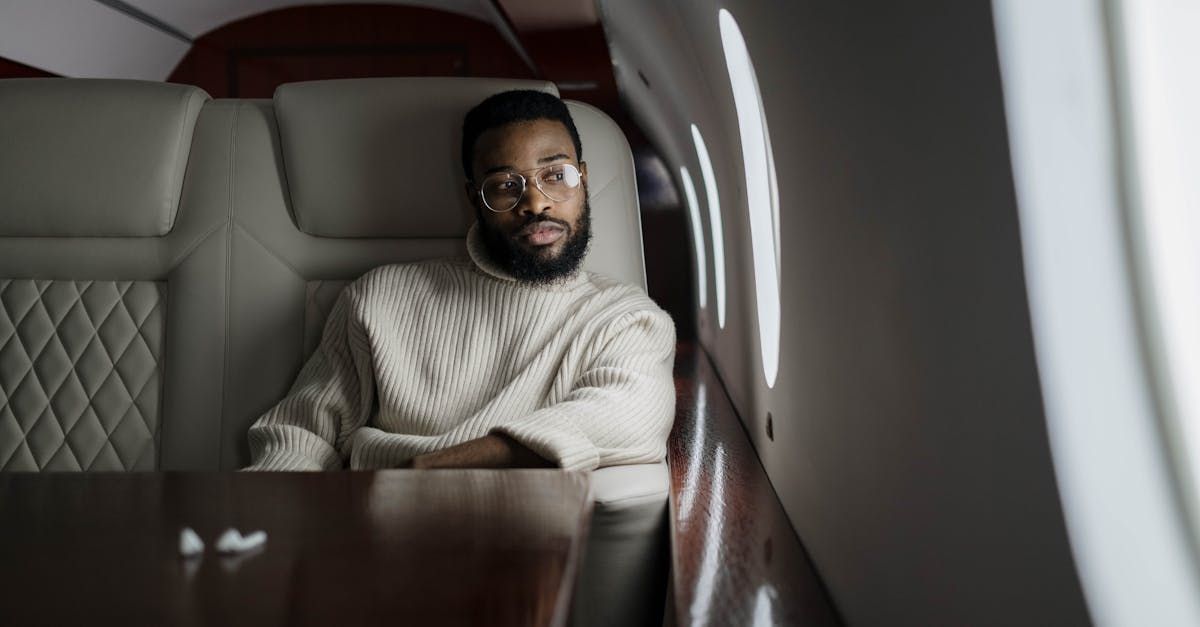A man is sitting in the back seat of a private jet.