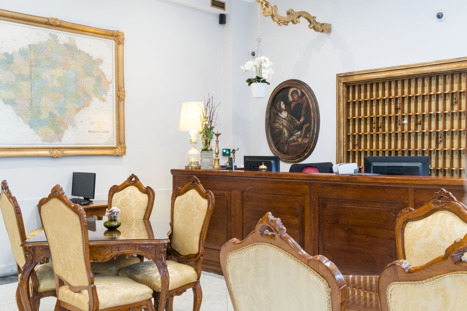 Reception dell'hotel con mobili decorati, mappa e opere d'arte.