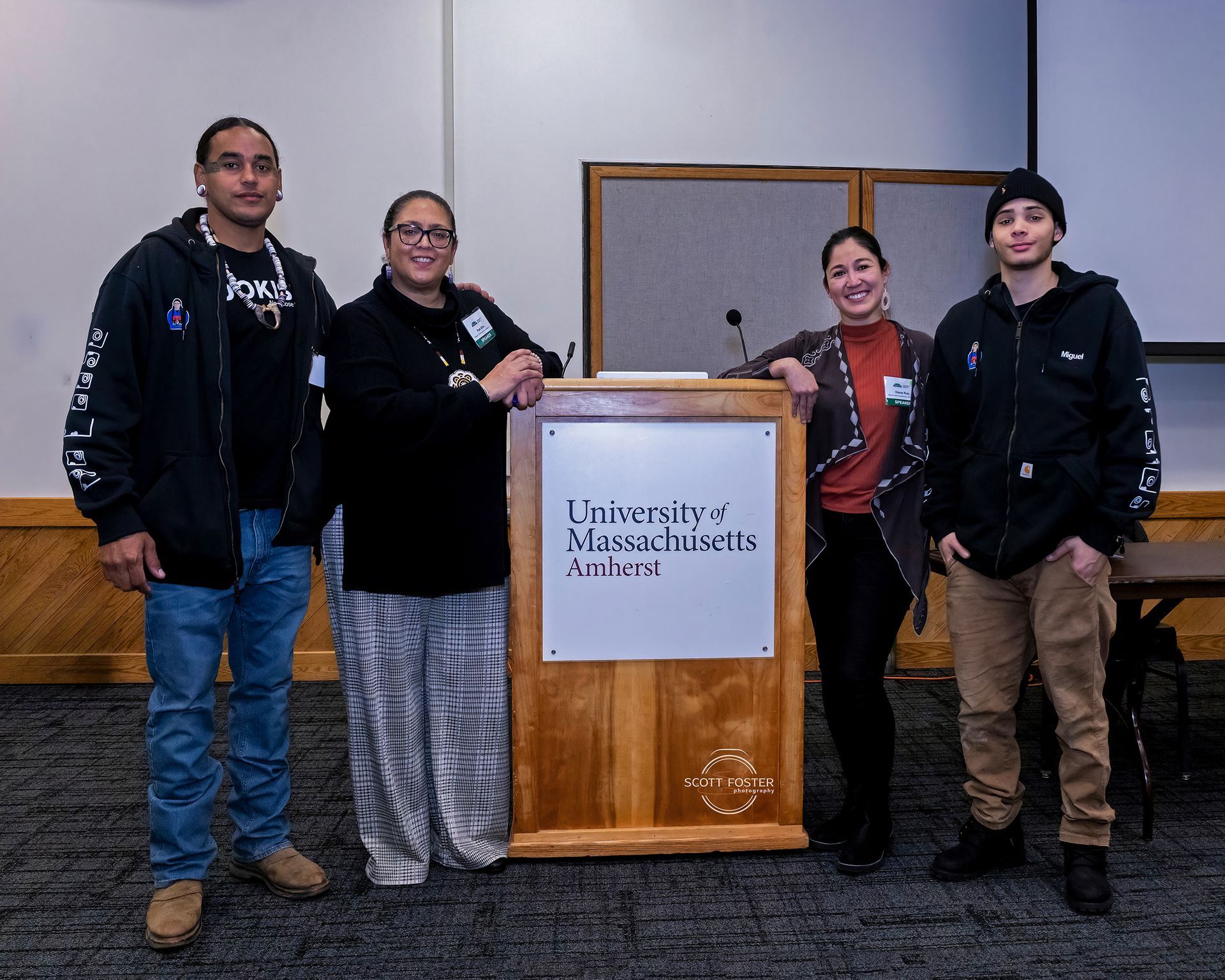 Four people stand near a podium with 