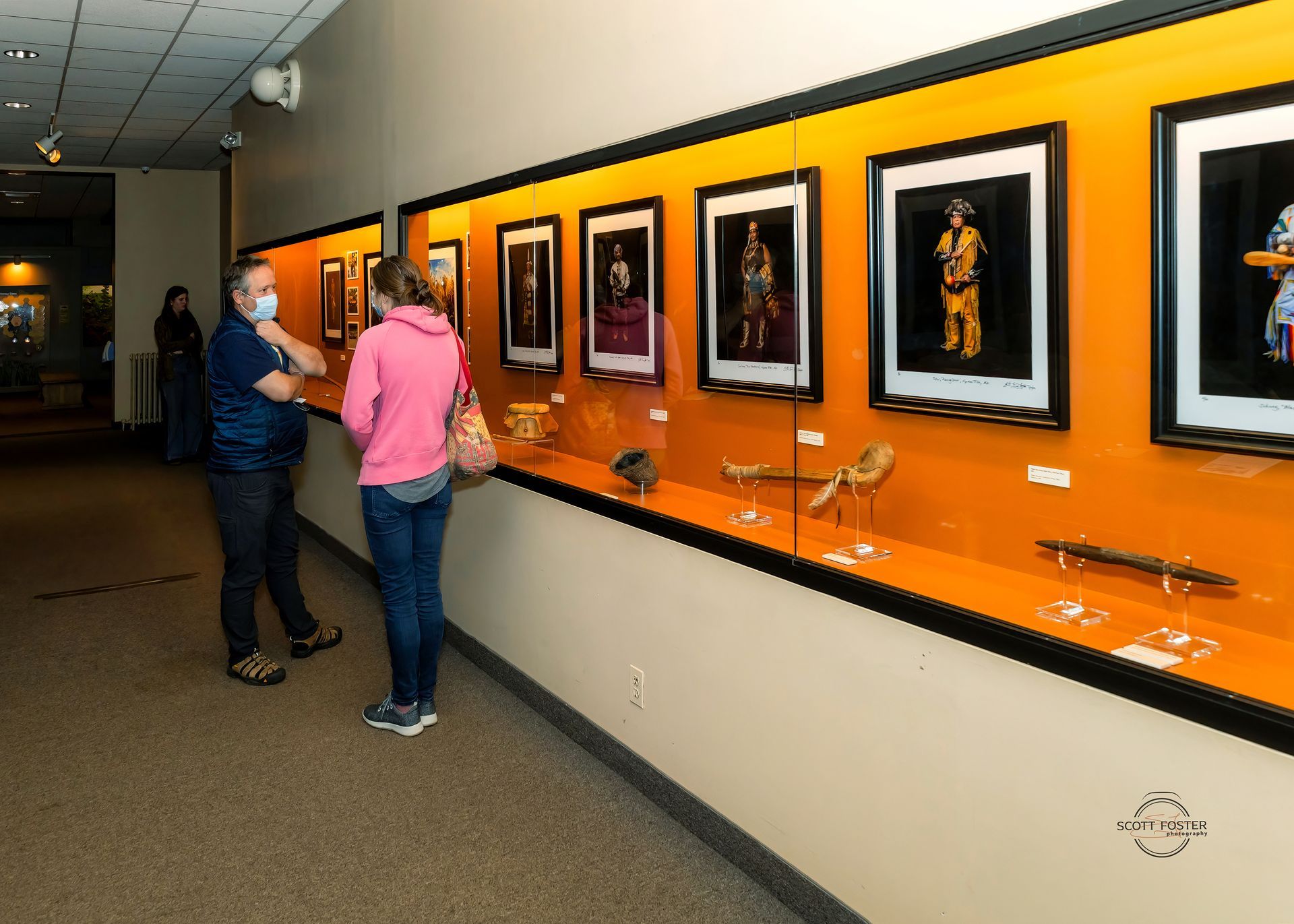 People viewing Native American art display in museum.