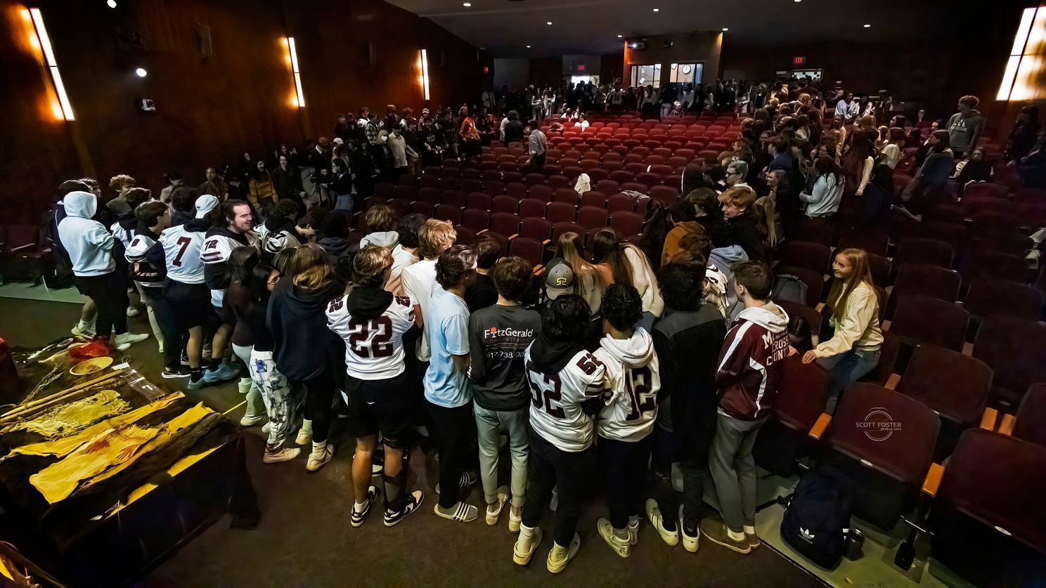 Group of students gather in an auditorium, likely for a school event.