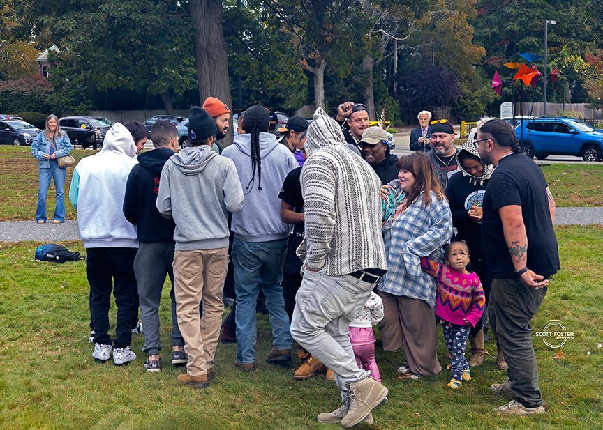 Group of people gathered on a grassy area outdoors. 
