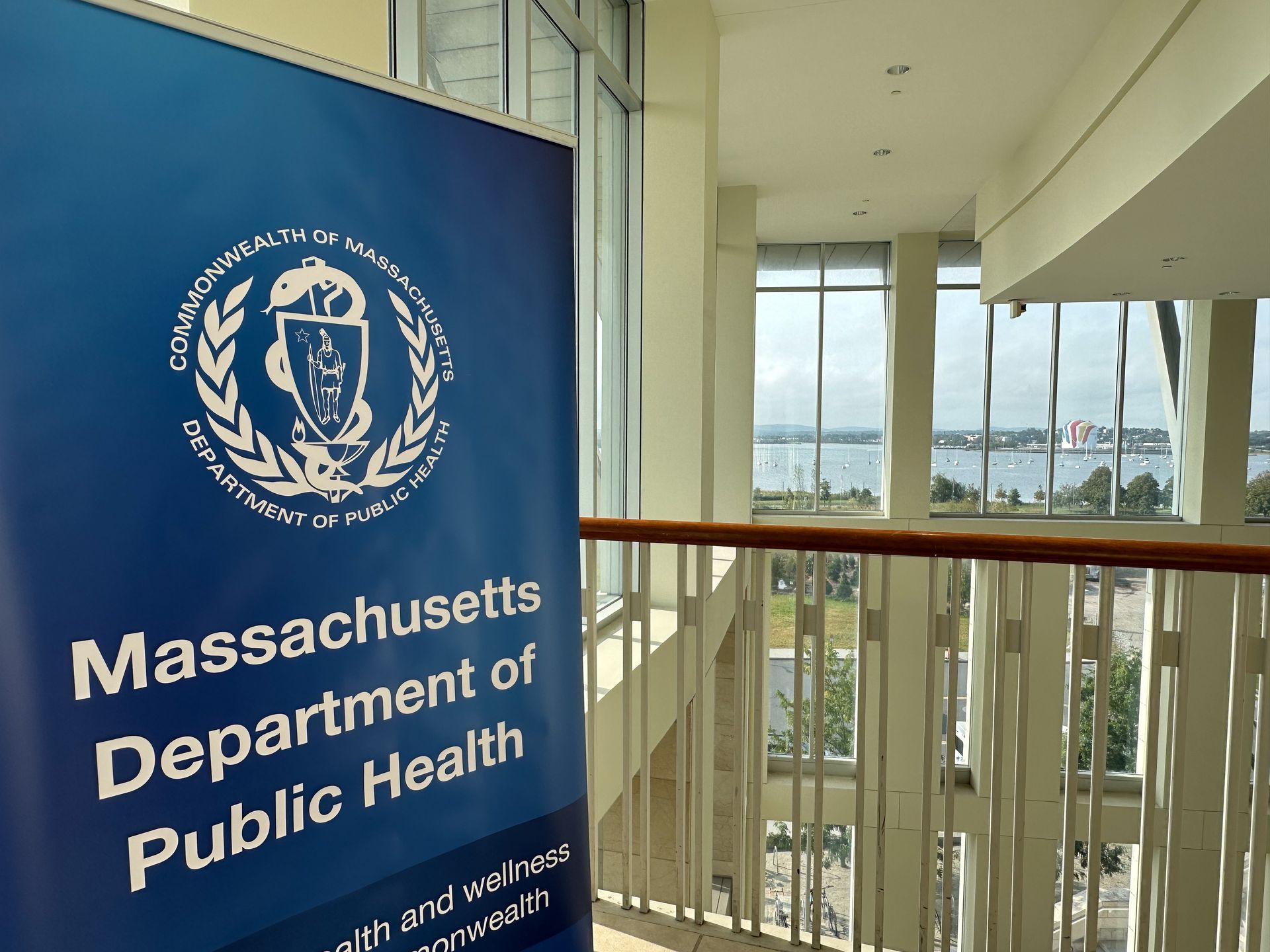 Massachusetts Department of Public Health sign inside a building with a water view.