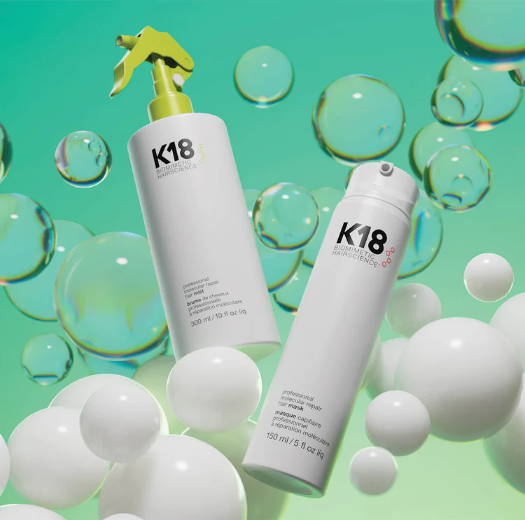 K18 haircare bottles on a mint-green background with floating bubbles and spheres
