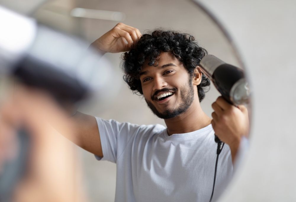 A Man With a Beard is Standing in Front of a Mirror in a Barber Shop — Hairdresser at Work in Cairns City, QLD