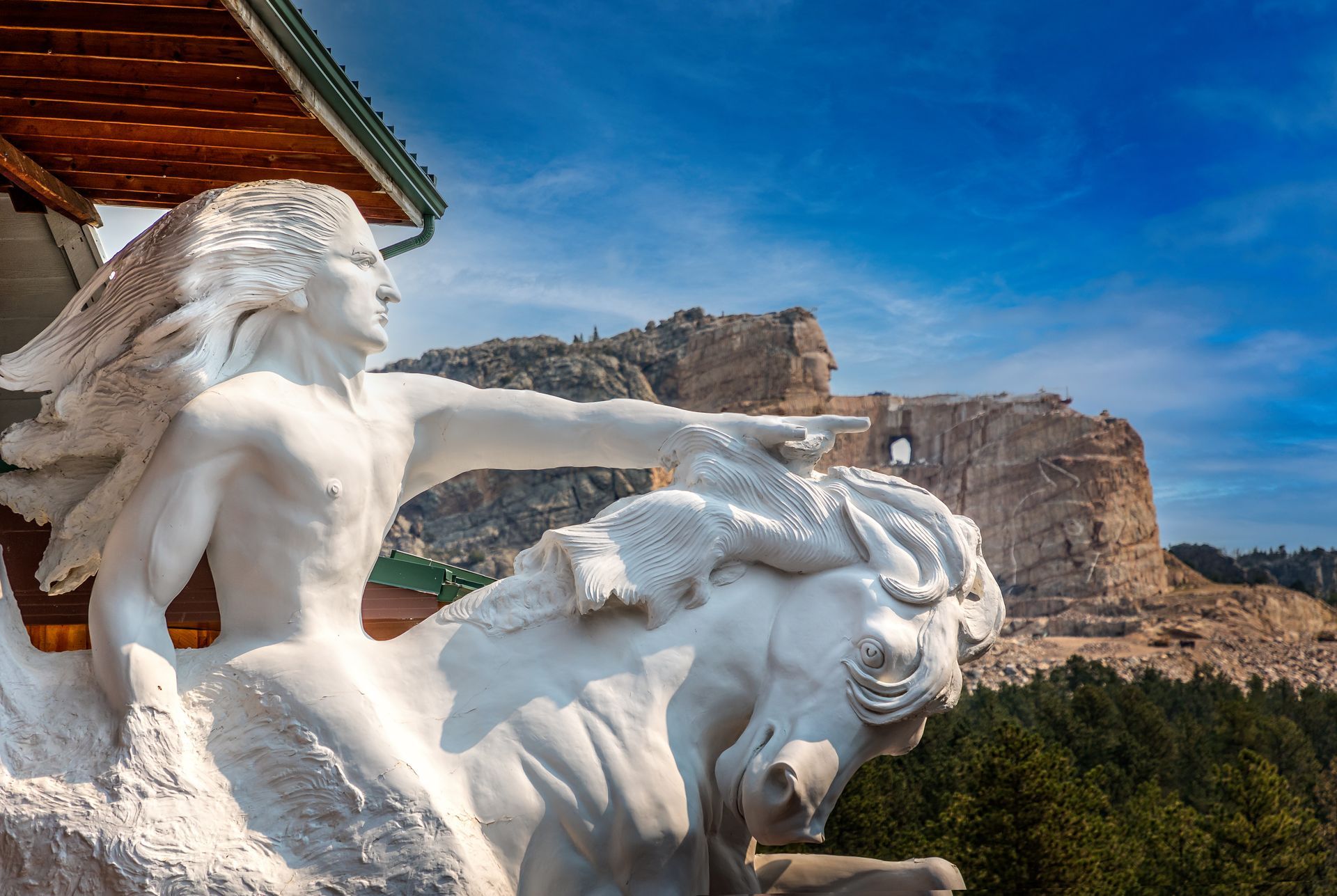White lion statues beside a temple, with a rocky cliff and blue sky in the background