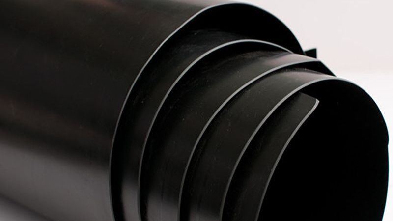 Black cylindrical object with ribbed rings and a rounded open end against a dark background