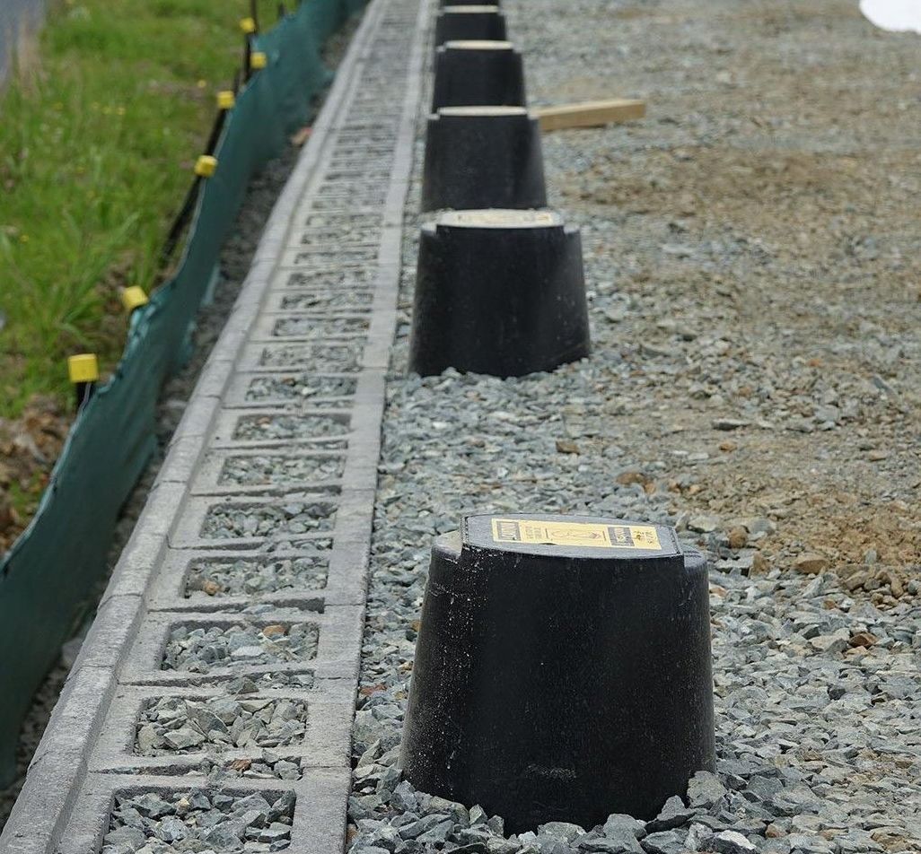 SleeveIt Row of black rubber edge markers beside a gravel path and green mesh fence.