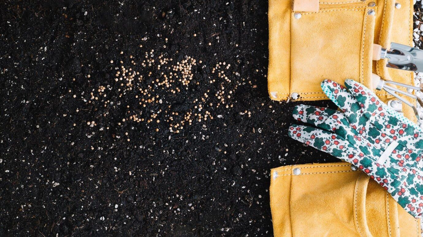 Gloved hands brushing gold granules from a black surface next to a yellow jacket with floral sleeves