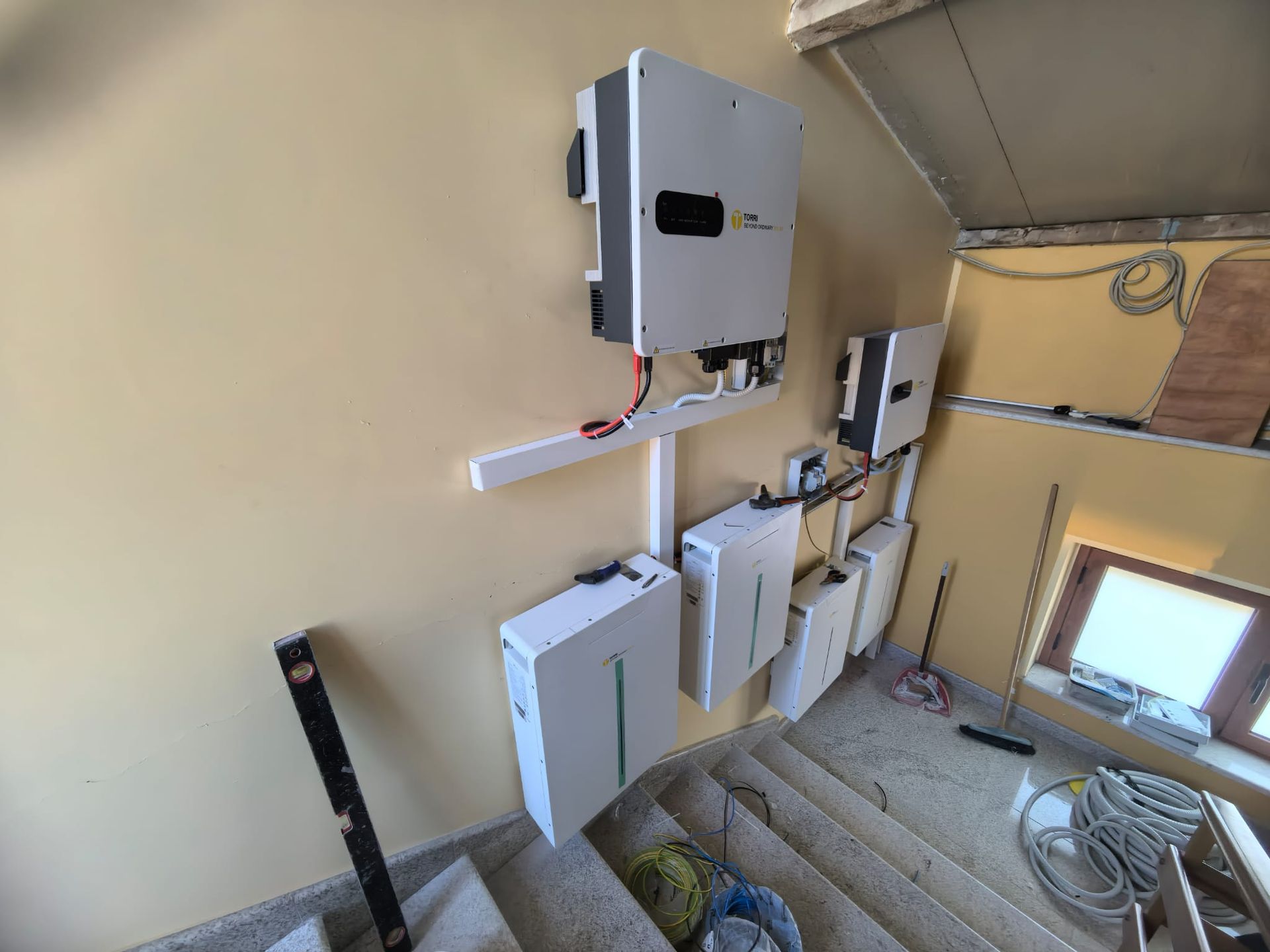Locale di servizio con pannelli elettrici a parete, canaline e una piccola finestra nel seminterrato.