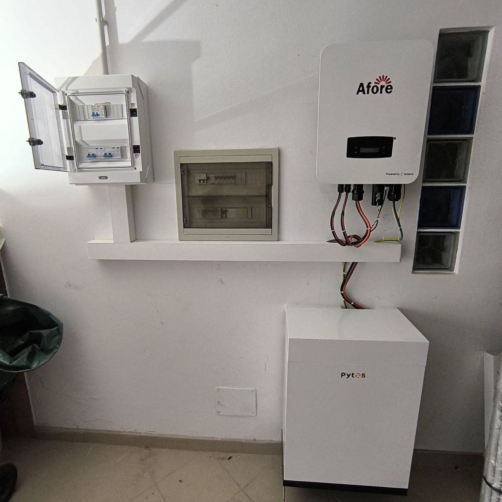 Apparecchiature elettriche a parete e quadro elettrico sopra un armadietto bianco in un locale di servizio.