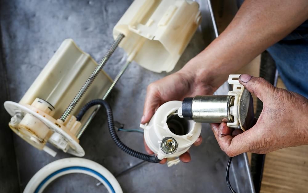 A Person Is Holding A Fuel Pump In Their Hands — Reef Diesel Injection In Mackay, QLD