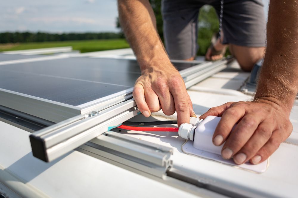 Person Installs Solar Panel on Vehicle Roof — Total Caravan Repairs in Taree, NSW
