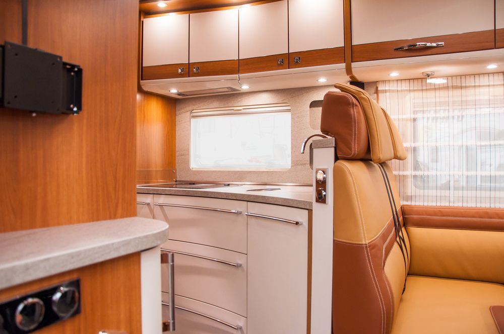 RV Interior With Kitchen, Cabinets, Seating, and a Window — Total Caravan Repairs in Nabiac, NSW