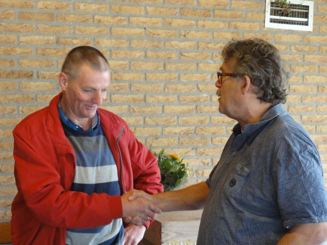 De voorzitter huldigt de jubilaris.
