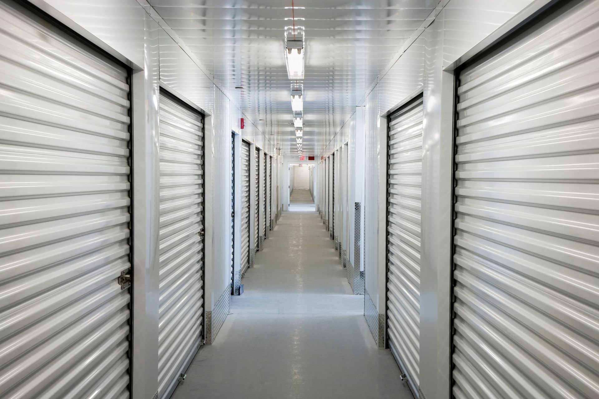 Storage facility installation with indoor hallway and secure roll-up metal unit doors.
