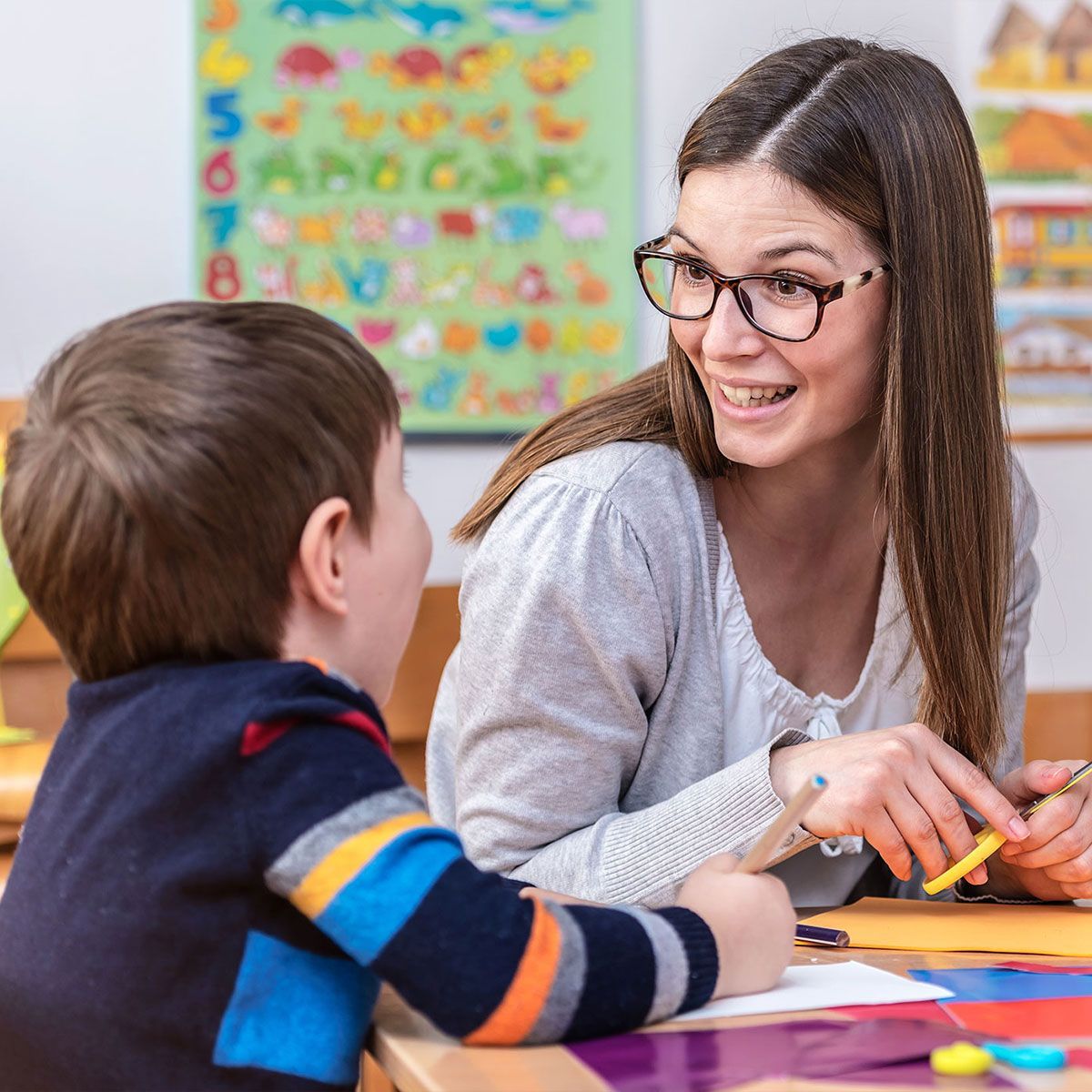 Kindergarten Teacher Works With Child