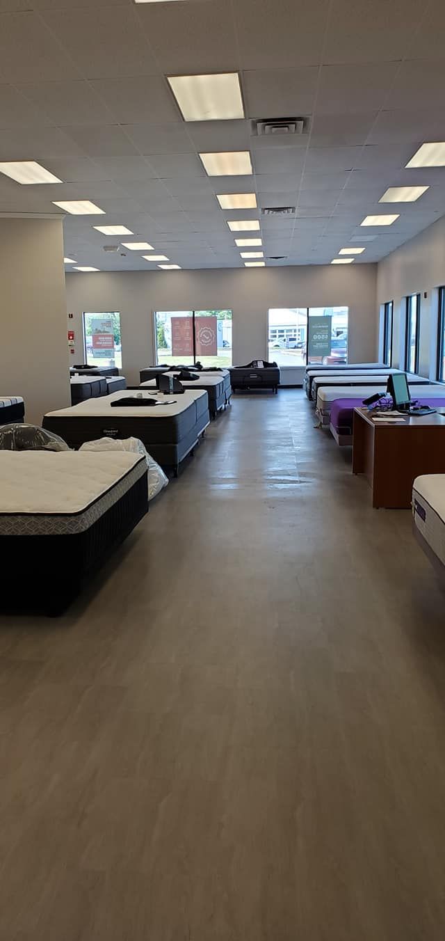 Interior of a mattress store with multiple beds on display.