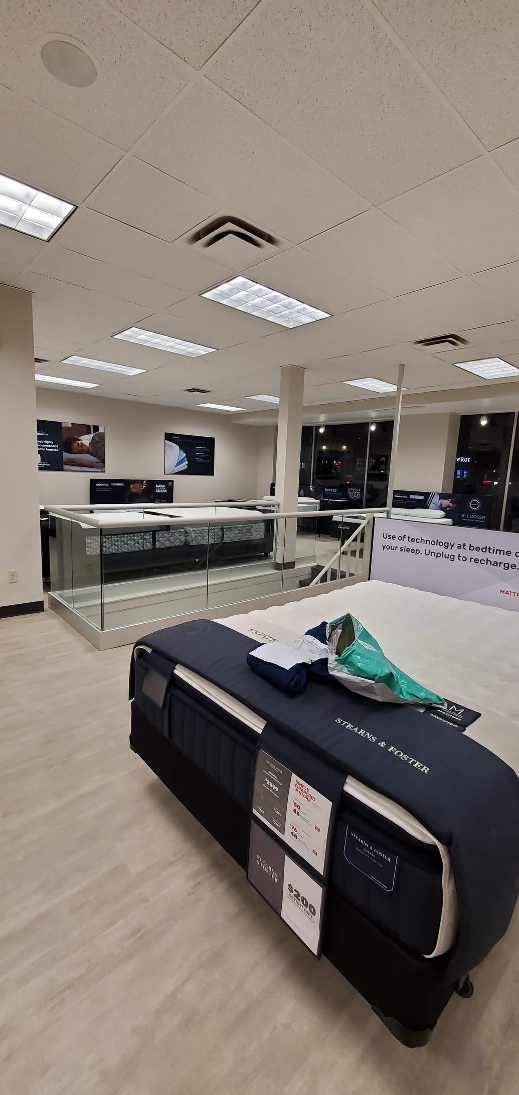 A showroom with a mattress on display and other mattresses in the background.