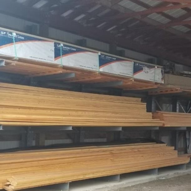Stacks of lumber stored on metal racks inside a warehouse
