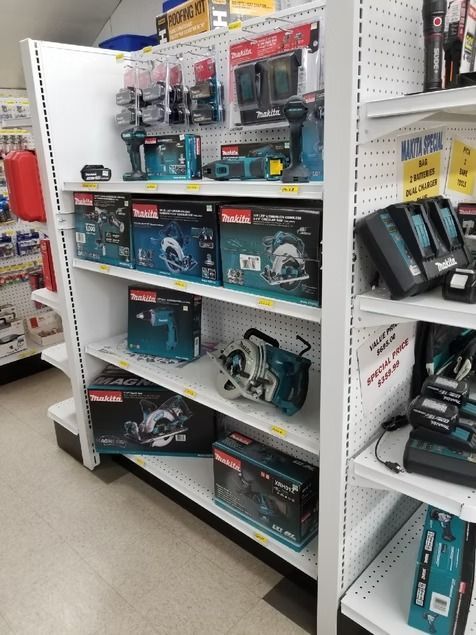 Retail shelf displaying boxed power tools and accessories in a hardware store aisle