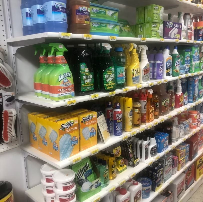 A grocery store shelf stocked with assorted cleaning products and detergents in colorful bottles and boxes