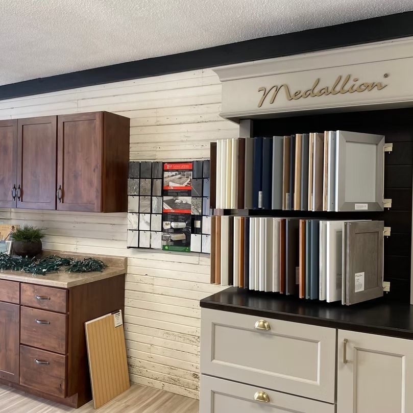 Kitchen display wall with countertop cabinets and a stack of metal finish samples under “Medallion” sign