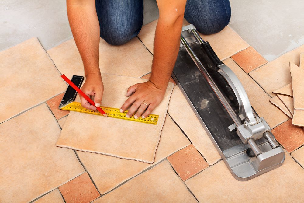 A Man is Measuring a Tile With a Tape Measure — Accurate Tiling MNC In Dunbogan, NSW