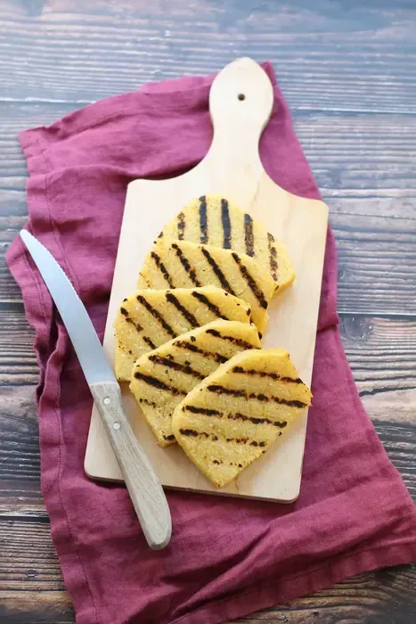 fettine di polenta su un tagliere di legno