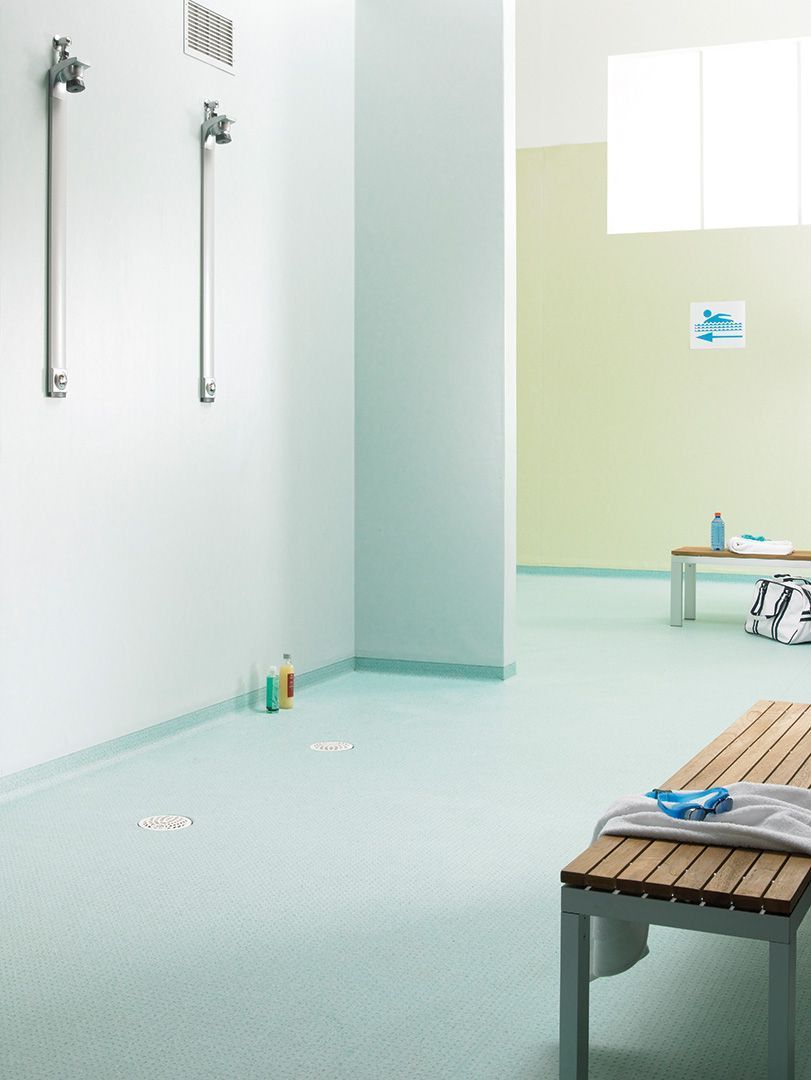 A Locker Room With a Wooden Bench in the Middle — John Chisholm Flooring in Cairns, QLD
