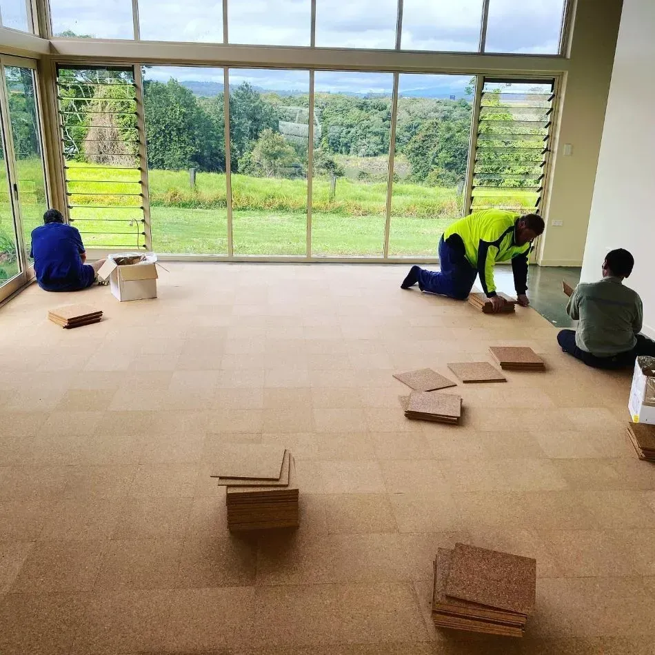 A Group of People Are Working on a Cork Floor — John Chisholm Flooring in Cairns, QLD