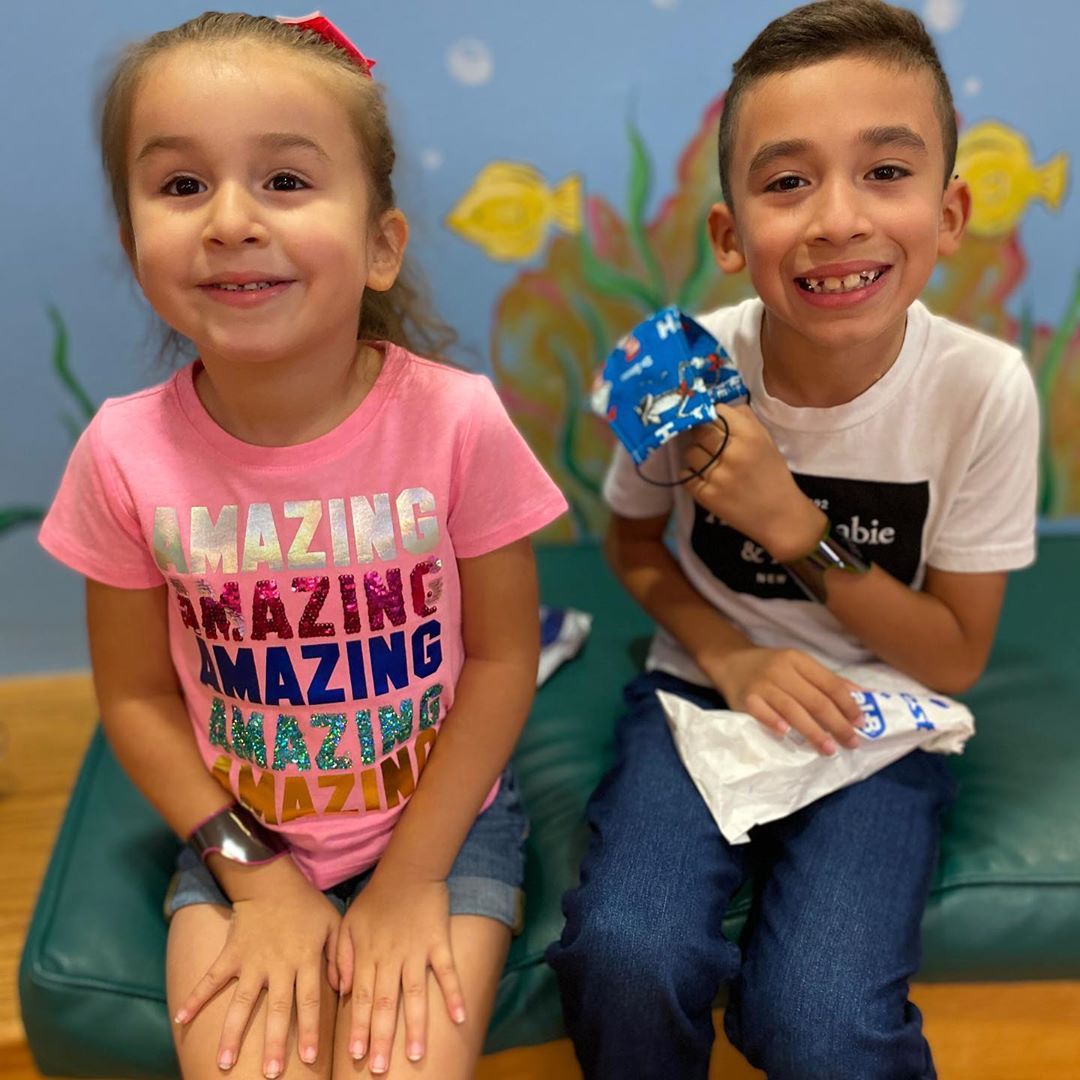 A boy and a girl are sitting next to each other and the girl has an amazing shirt on