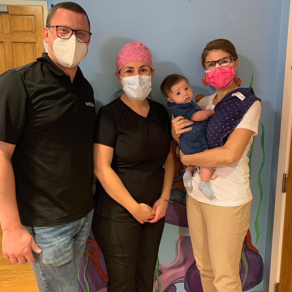 A group of people wearing face masks standing next to each other